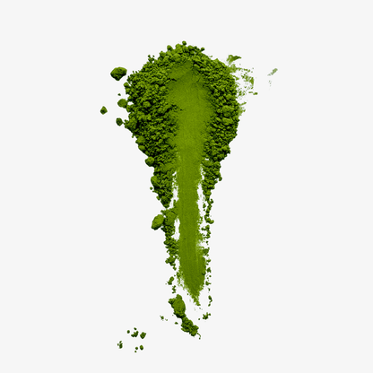 Bright green matcha powder spread in a tapered sweep on a white background, showing its fine texture and small clumps.