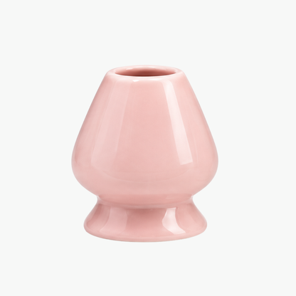 Rosa glasierter Matcha-Besenhalter aus Keramik mit rundem, konisch zulaufendem Körper und ausgestelltem Fuß, der die Bambusborsten beim Trocknen stützt.