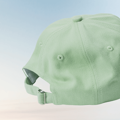 Back view of the matcha-green Energise Focus Glow cap, showing its adjustable fabric strap, metal buckle and stitched ventilation eyelets.